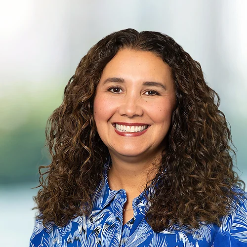 A photo of attorney Perla Duvel against a softly blurred office background
