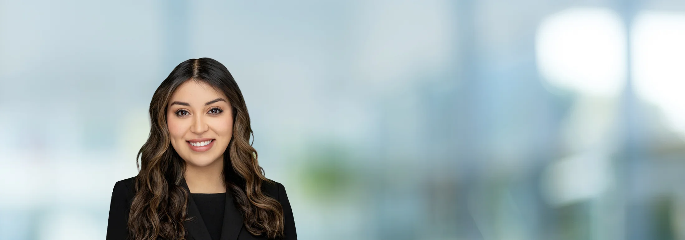 A photo of attorney Demi Flores against a softly blurred office background