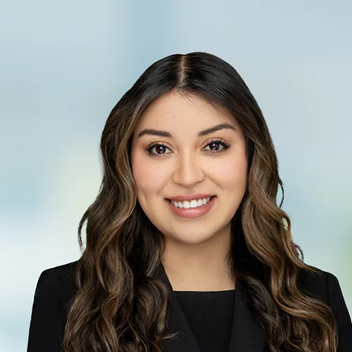 A photo of attorney Demi Flores against a softly blurred office background
