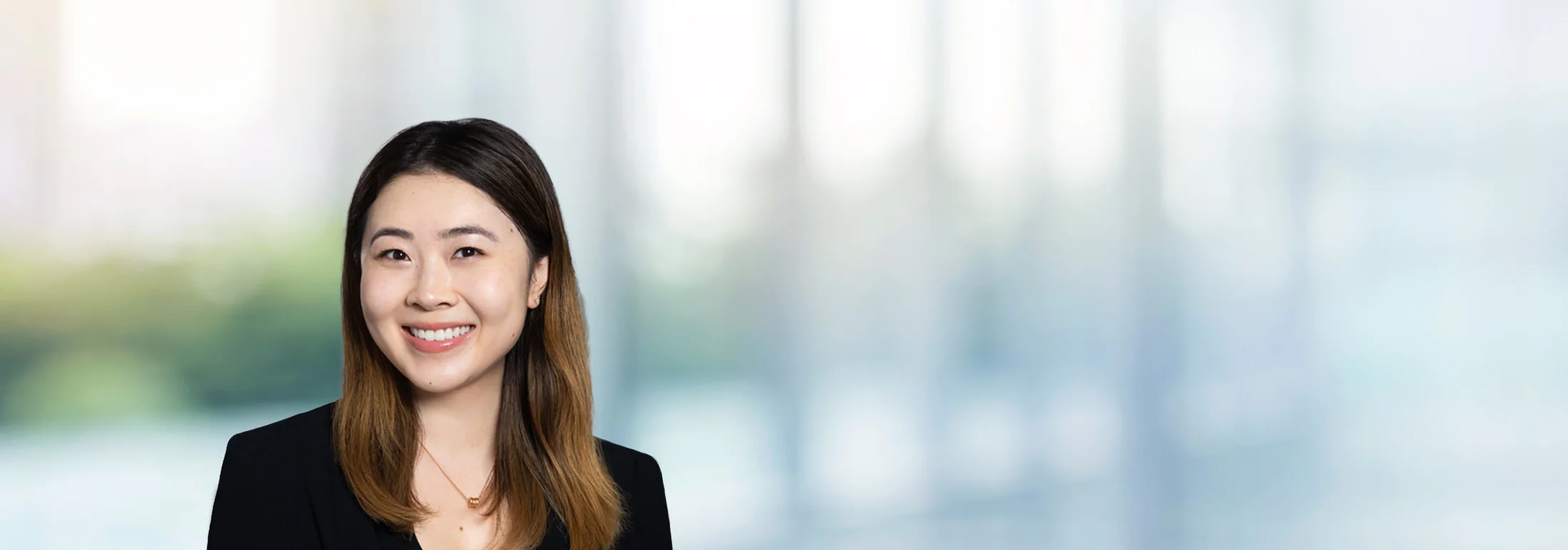 A photo of attorney Amy Qi against a softly blurred office background