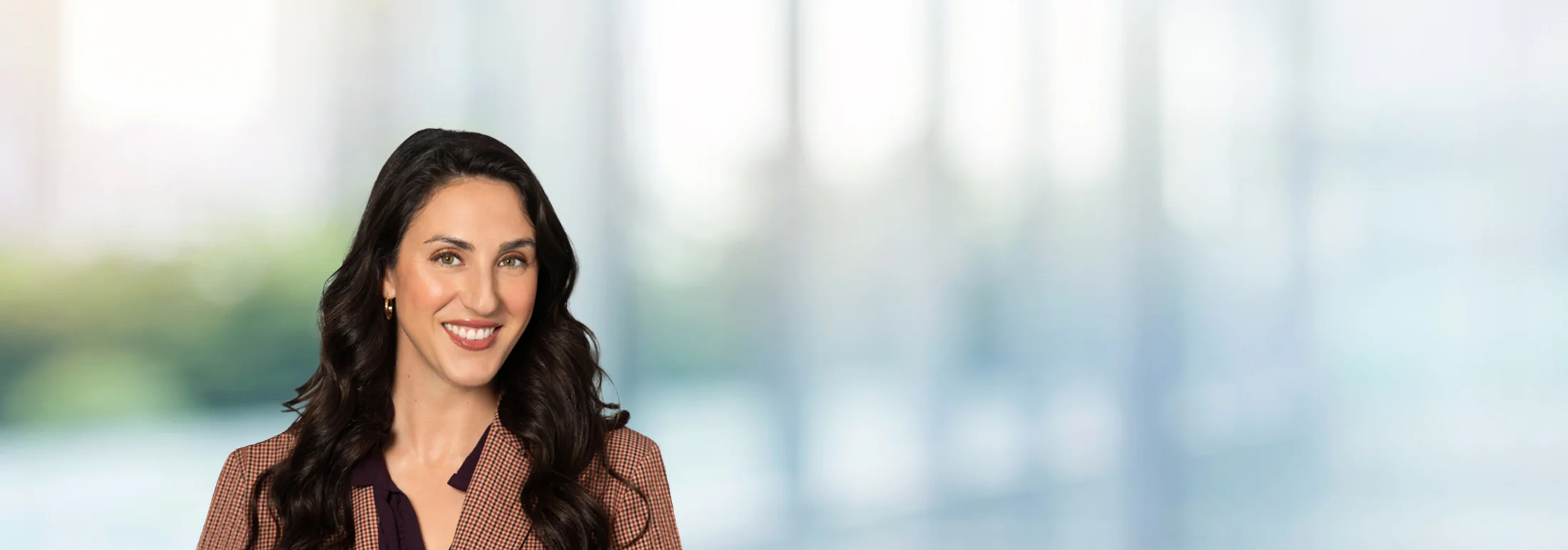 A photo of attorney Thalia Rofos against a softly blurred office background