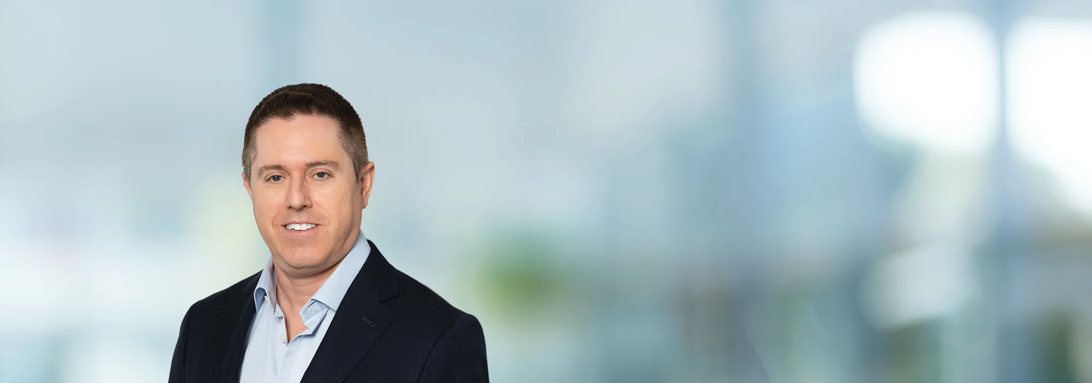 A photo of attorney, Matt Sgnilek, against a softly blurred office background
