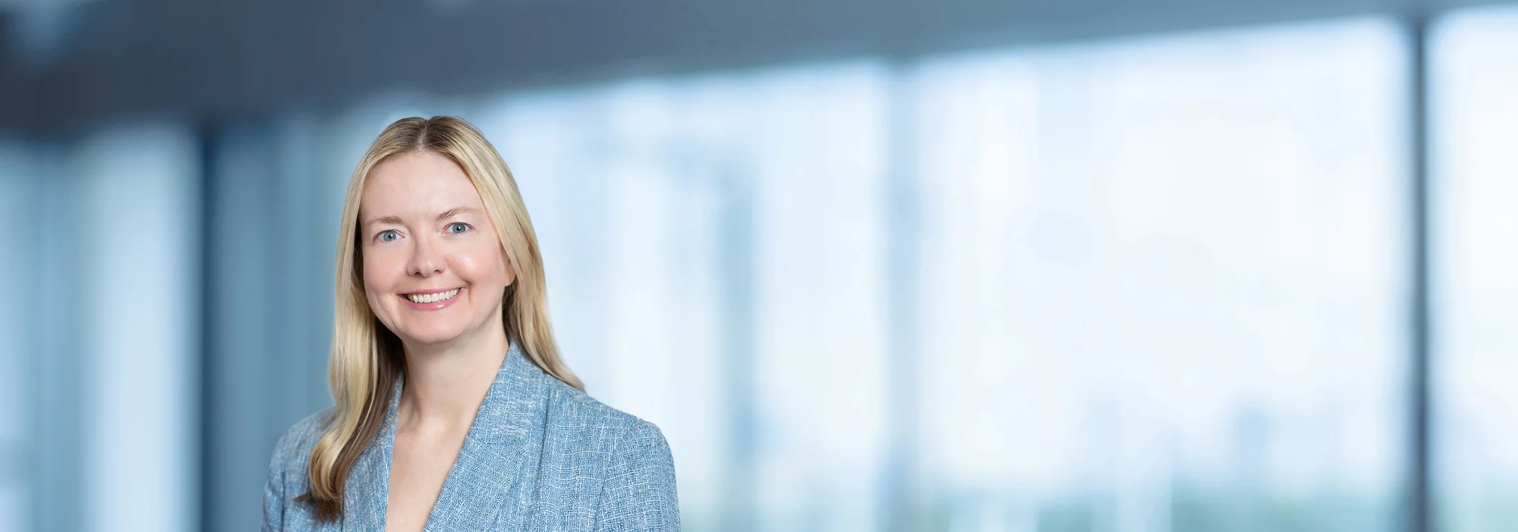A photo of attorney, Katherine Den Bleyker, against a softly blurred office background