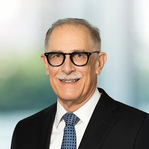 A photo of attorney Dennis Kasper against a softly blurred office background