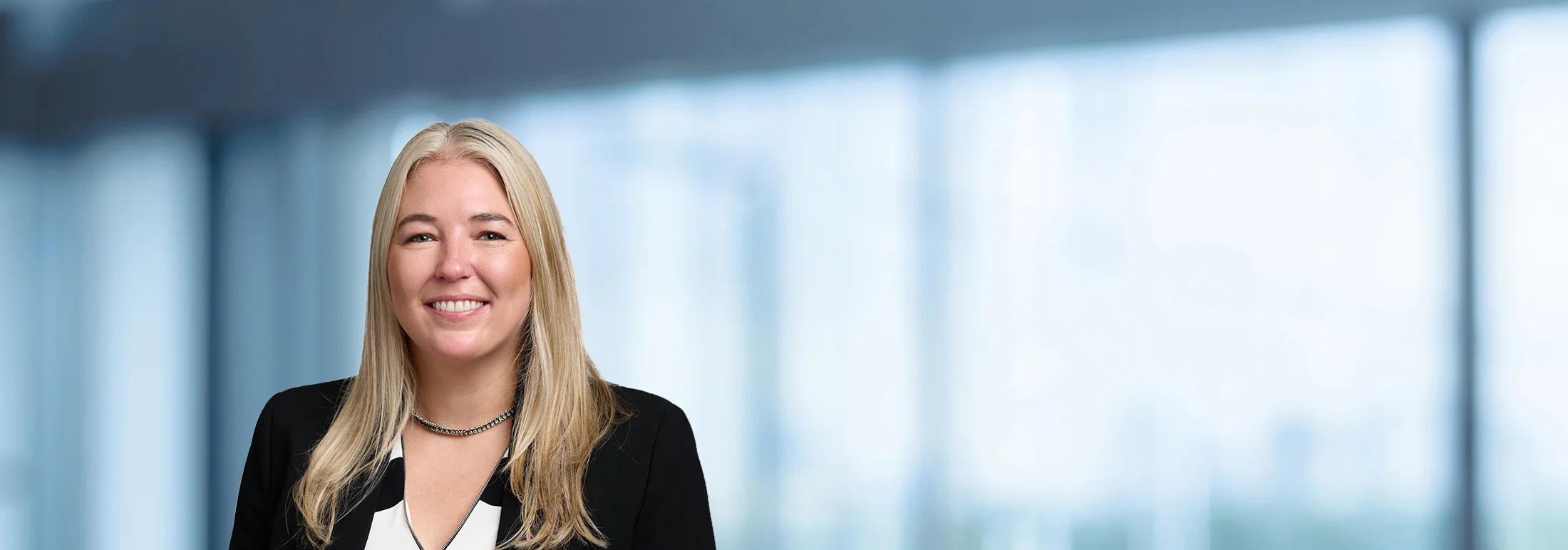 A photo of attorney Meghan McNally against a softly blurred office background