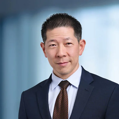 A photo of attorney Alex Wong against a softly blurred office background