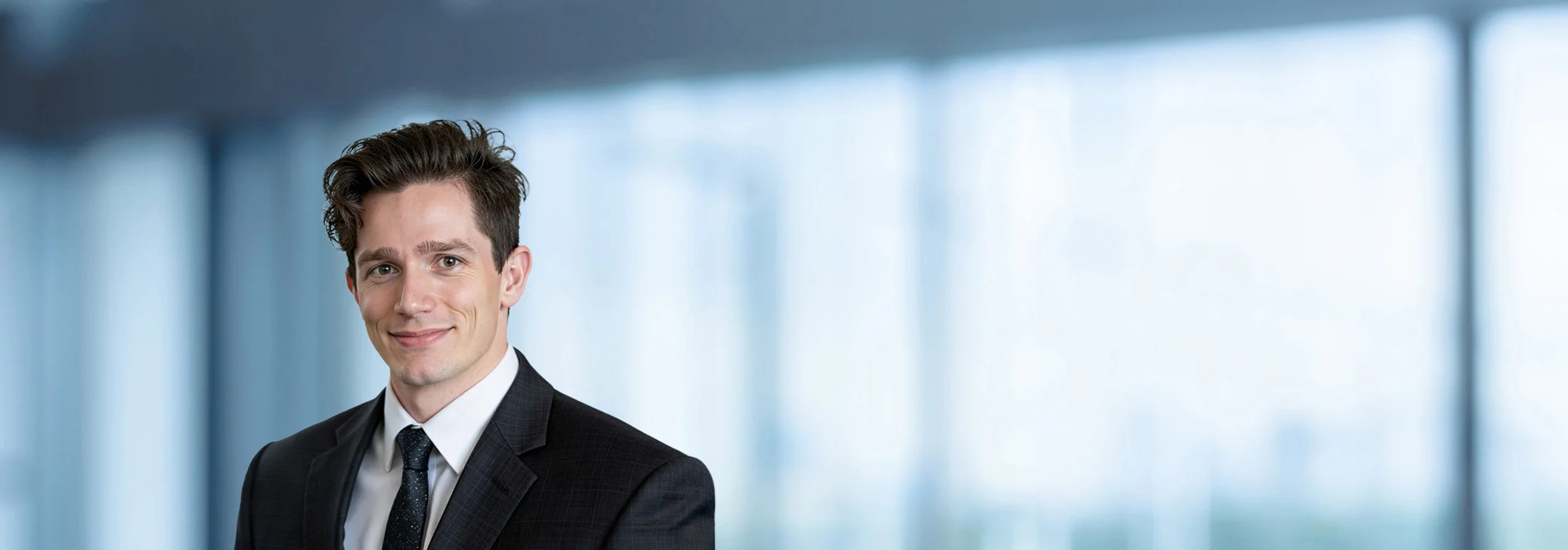 A photo of attorney Dusinh Pokorny against a softly blurred office background