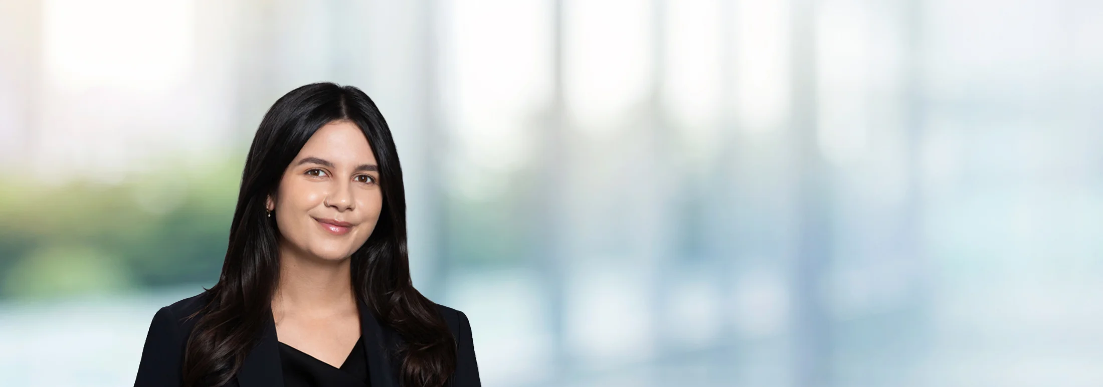 A photo of attorney Delilah Sadat against a softly blurred office background