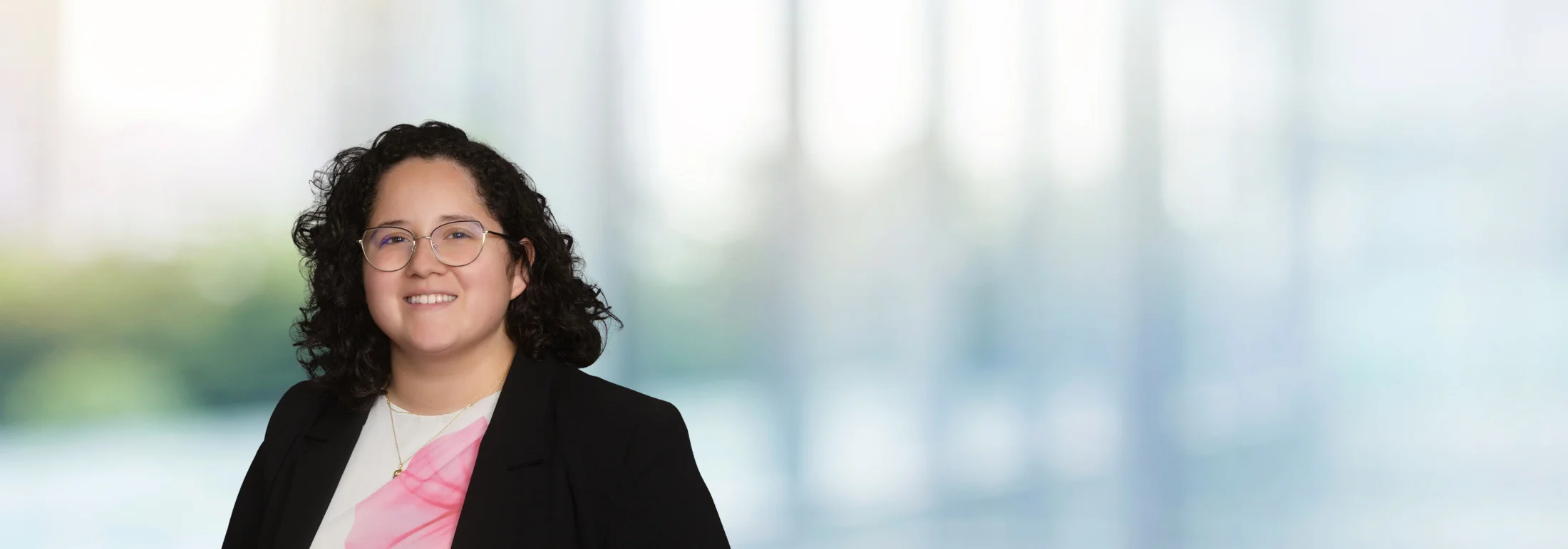 A photo of attorney Mizeille Avina against a softly blurred office background