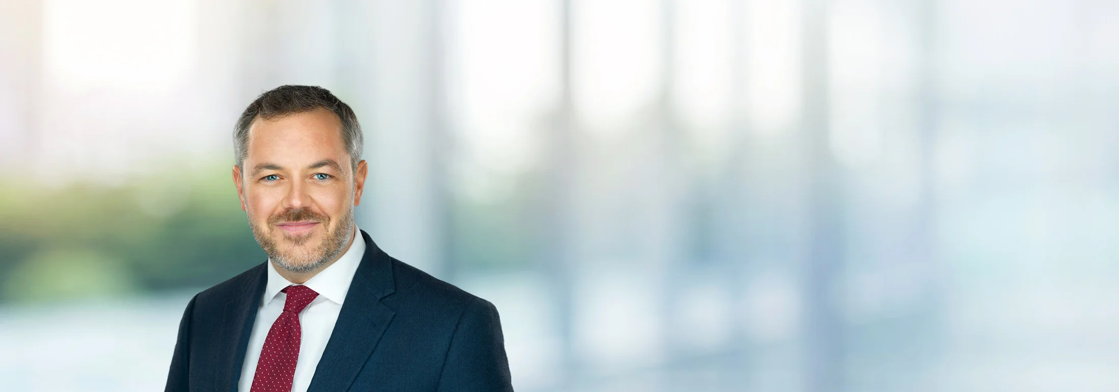 A photo of attorney, Chris Helsel, against a softly blurred office background.