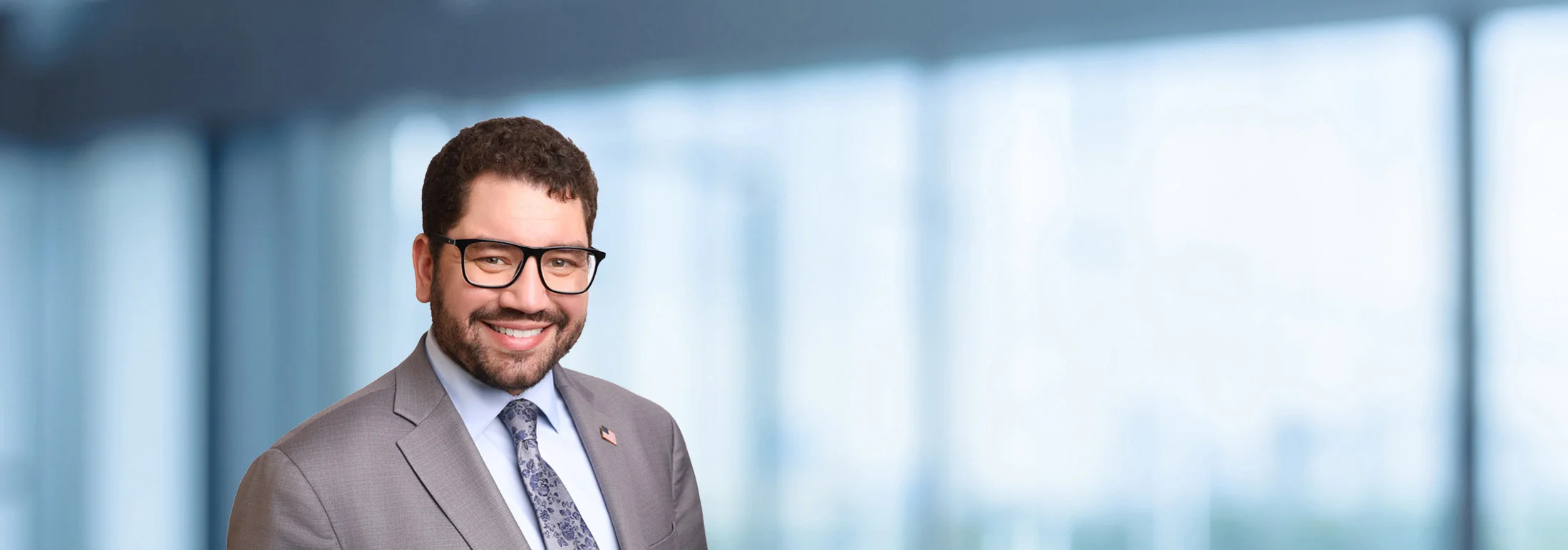 A photo of attorney Paul Carrion against a softly blurred office background