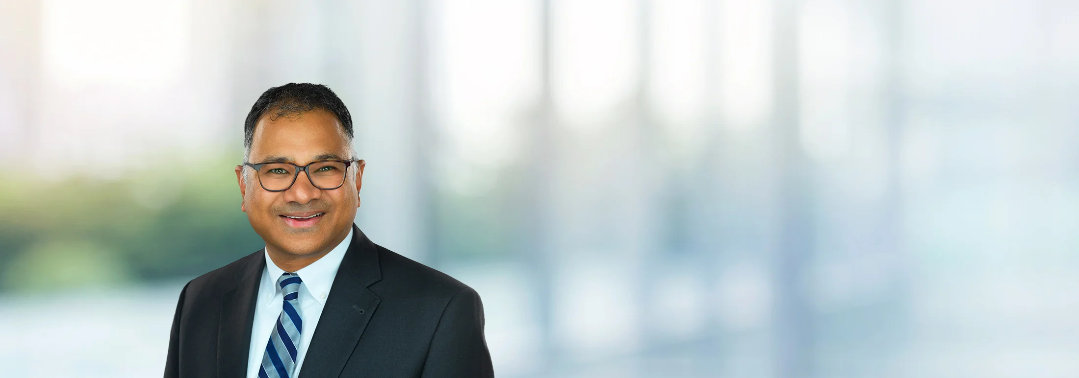 A photo of attorney, Les Machado, against a softly blurred office background.