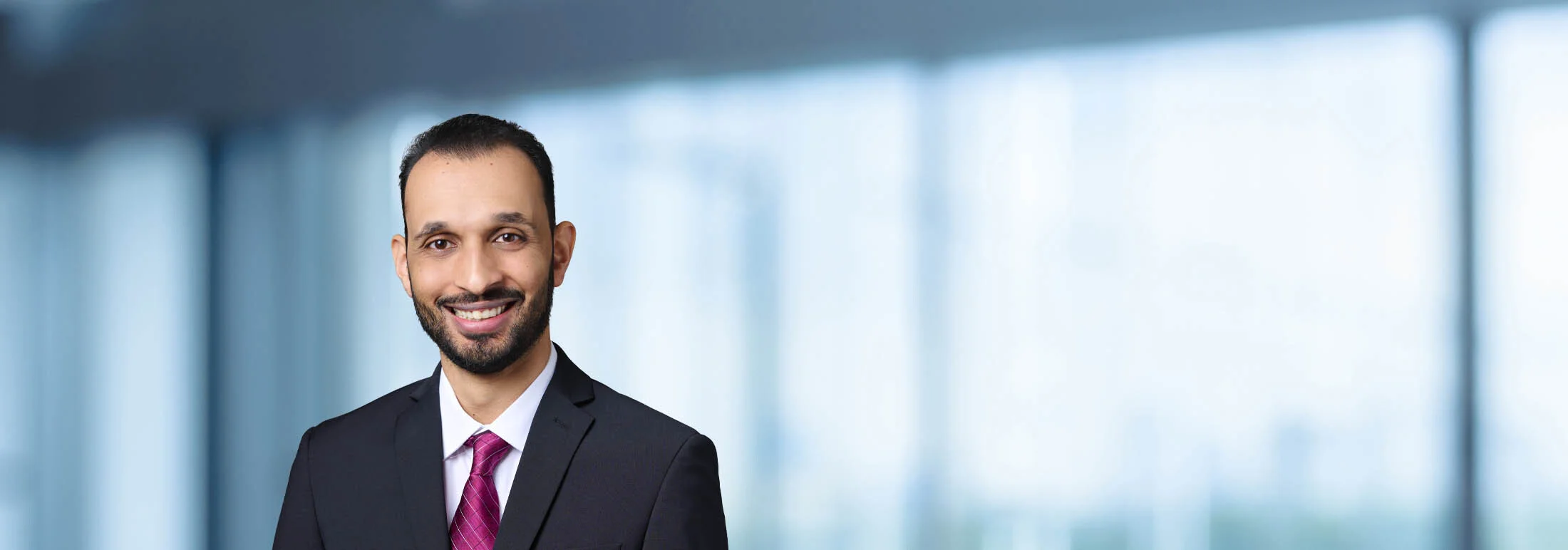 A photo of attorney Parshant Mahbubani against a softly blurred office background