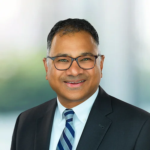 A photo of attorney, Les Machado, against a softly blurred office background.