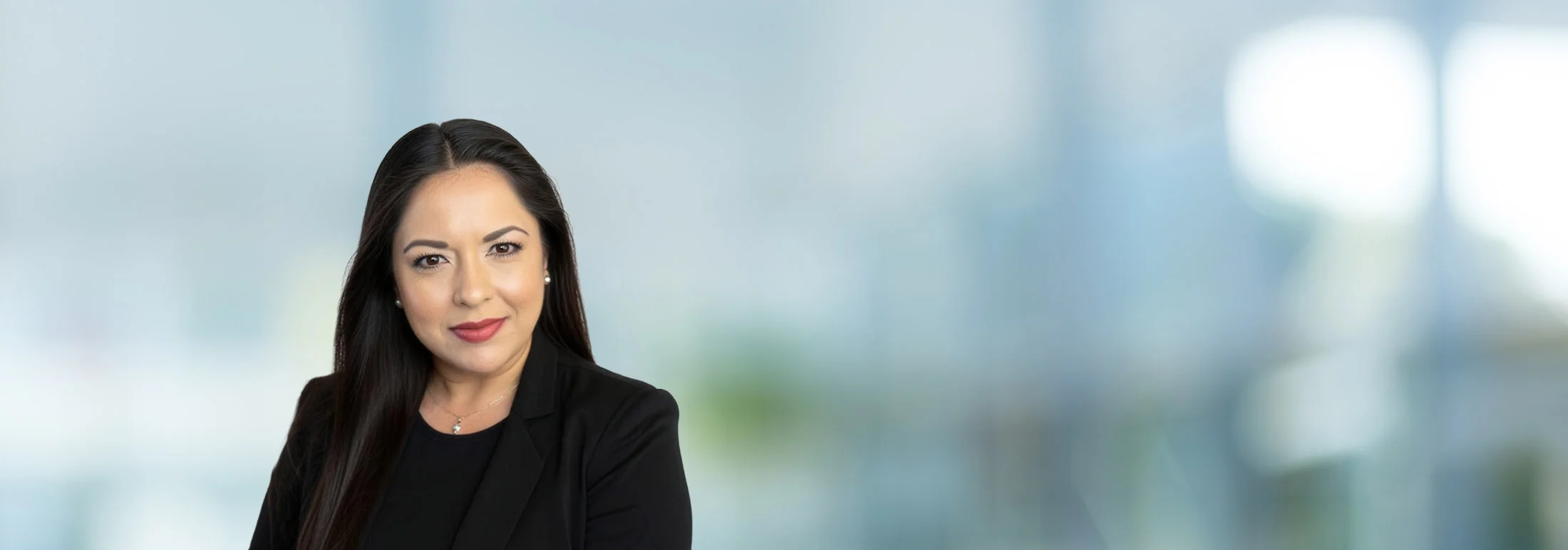 A photo of attorney Joana Brooker against a softly blurred office background.
