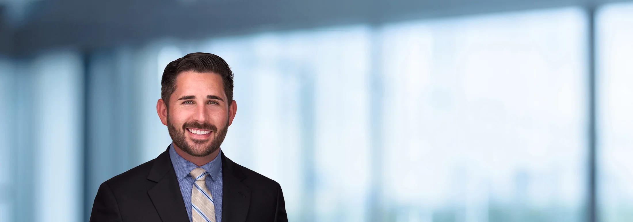 A photo of attorney Ryan Greene against a softly blurred office background.