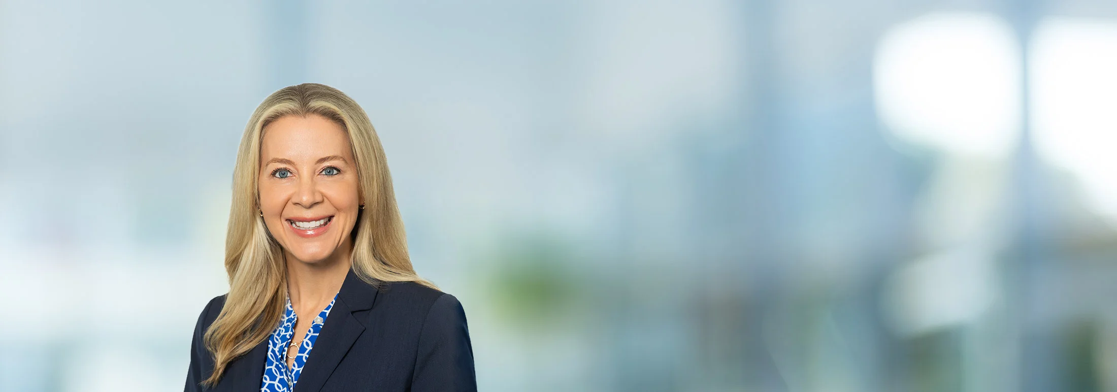 A photo of attorney, Katherine Akamine, against a softly blurred office background