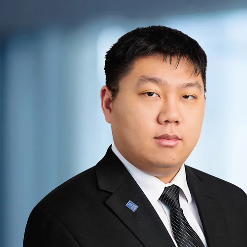 A photo of attorney, Daniel Wang, against a softly blurred office background.