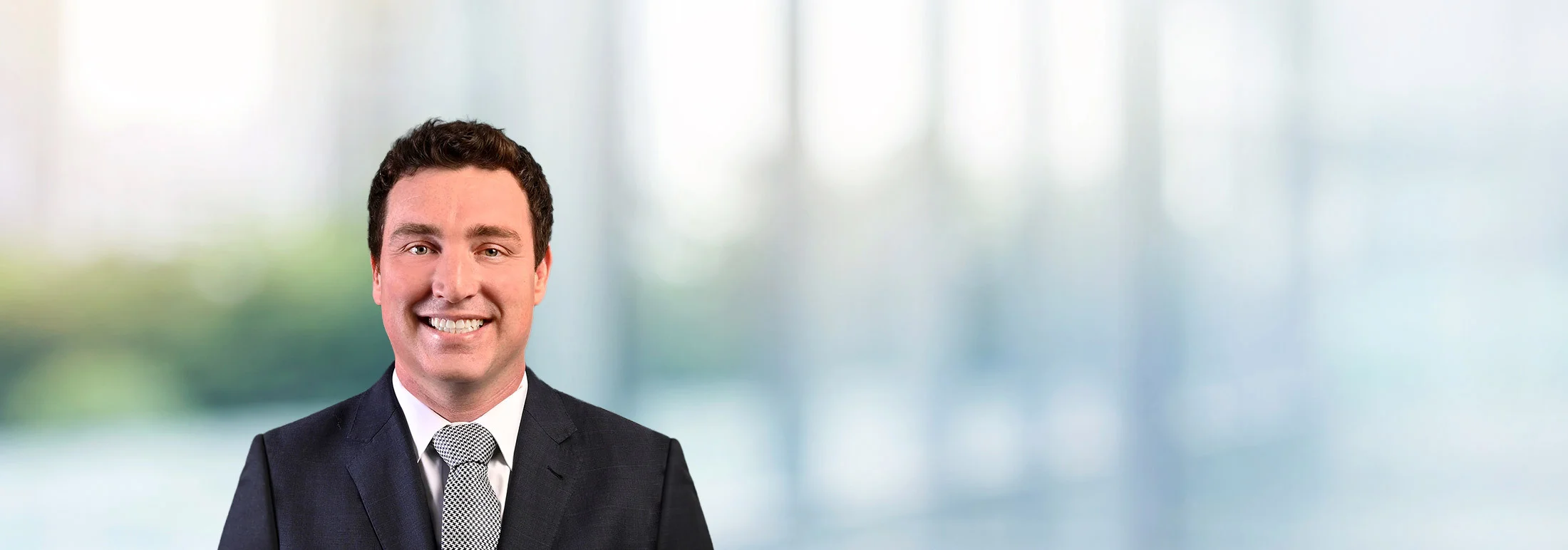 A photo of attorney Ryan Benson against a softly blurred office background