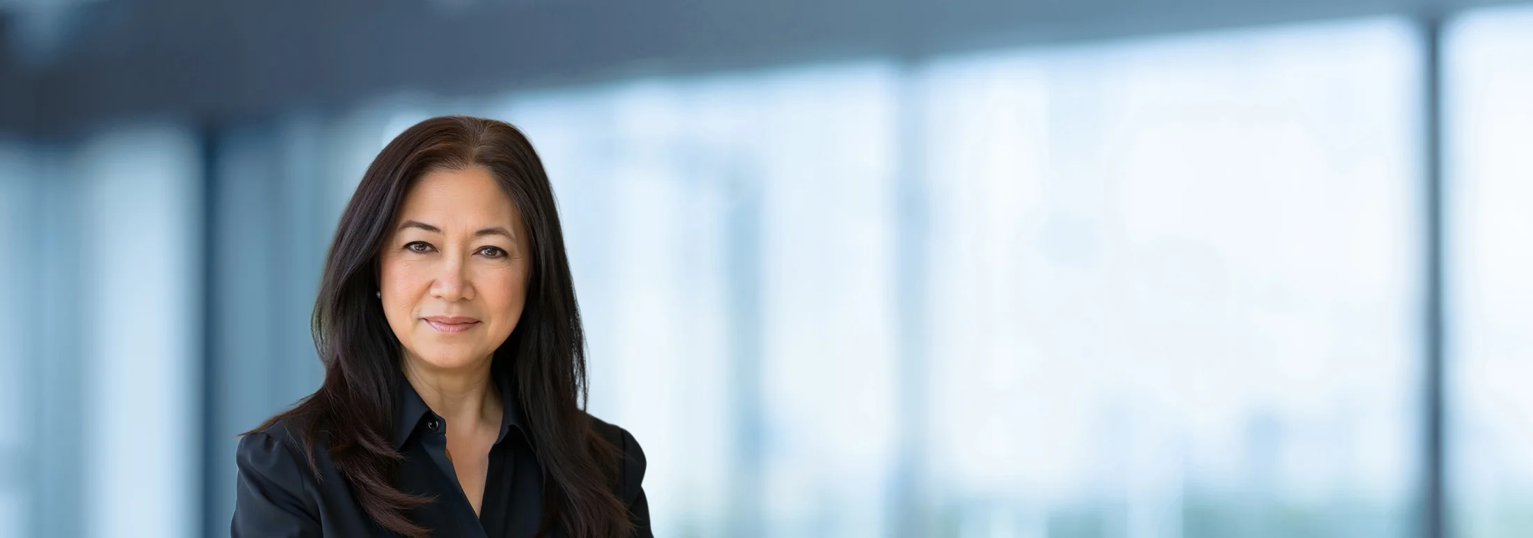 A photo of attorney, Angeli Aragon, against a softly blurred office background