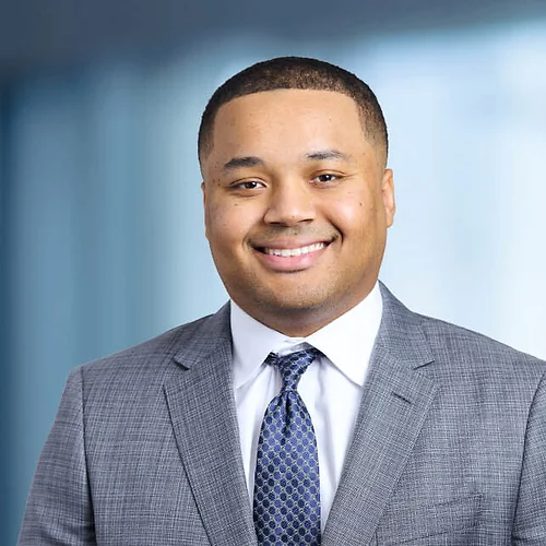 A photo of attorney Brennan Hughes against a softly blurred office background