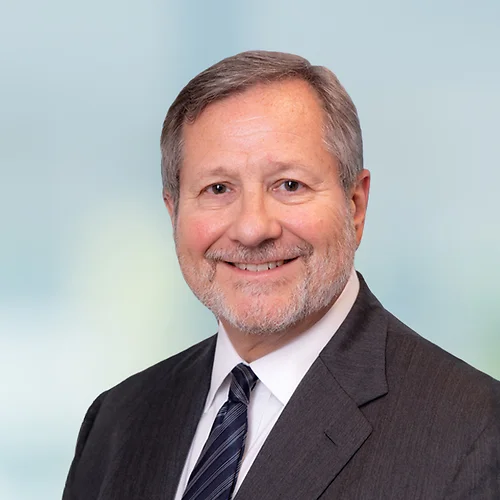 A photo of attorney, Mark Corner, against a softly blurred office background.