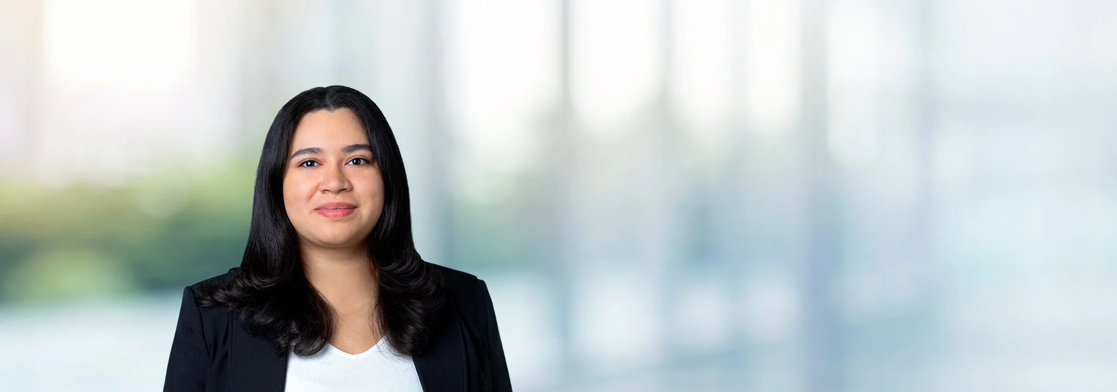 A photo of attorney, Lisbeth Valdez, against a softly blurred office background.