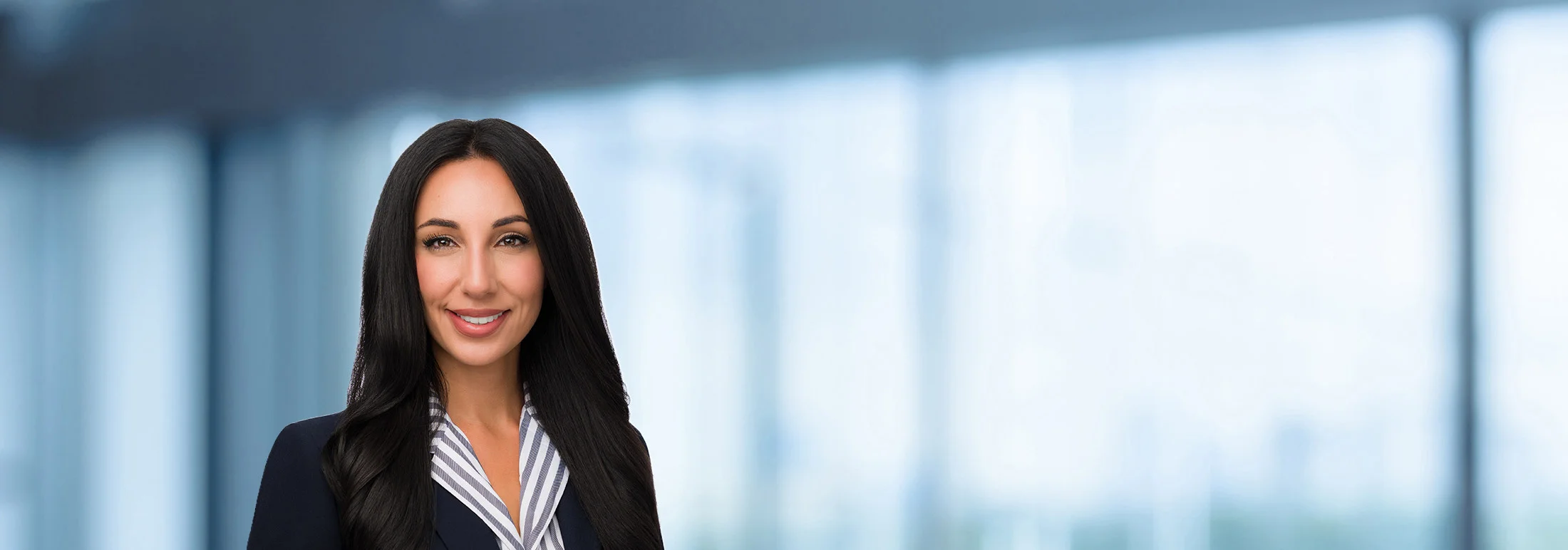 A photo of attorney, Kimya Liaghat, against a softly blurred office background