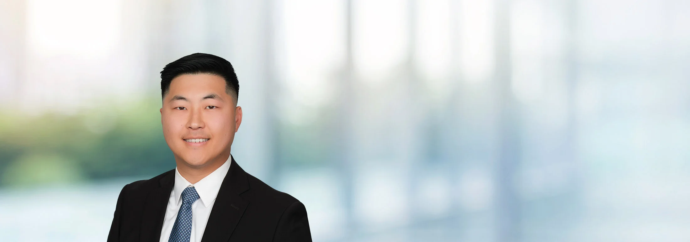 A photo of attorney Justin Kim against a softly blurred office background.