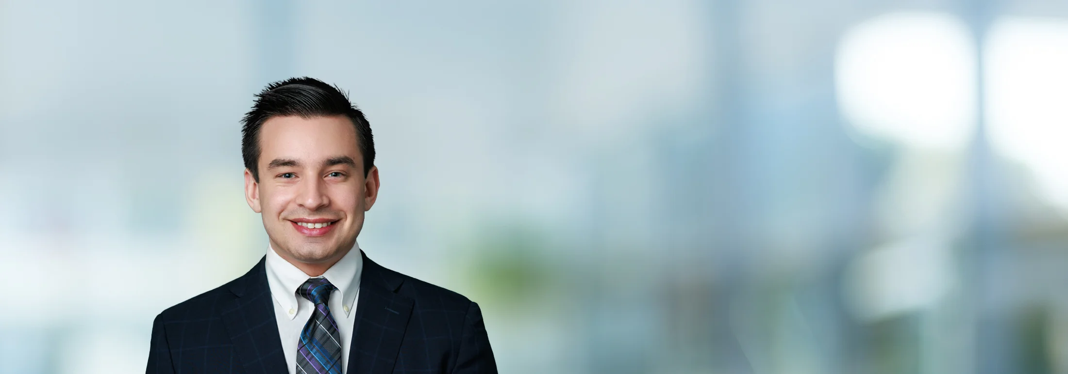 A photo of attorney, Sam Fenton, against a softly blurred office background.