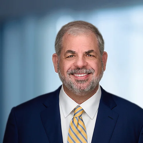 A photo of attorney John Meehan against a softly blurred office background