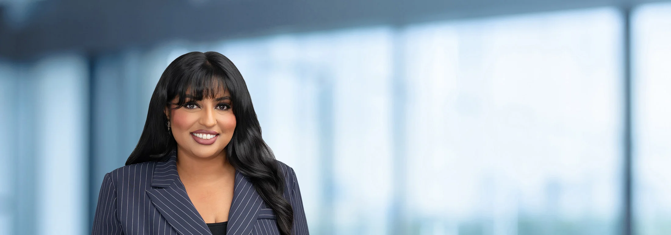A photo of attorney Ujala Batool against a softly blurred office background